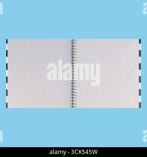 A blank spiral-bound notebook open to its pages, ready for notes, sketches, or creative ideas. Stock Photo