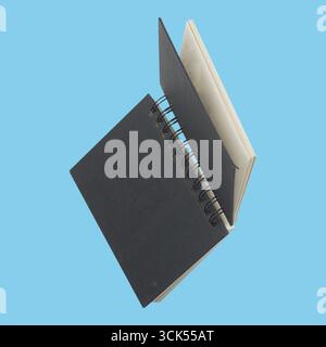 An open spiral-bound notebook with blank pages, suitable for writing, sketching, or note-taking. Stock Photo