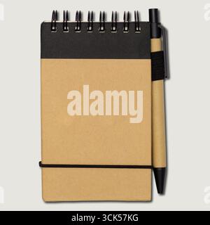 A spiral-bound notebook with a pen, ideal for note-taking or journaling. Stock Photo