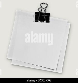 A blank notepad held by a black paper clip, ready for notes or reminders. Stock Photo