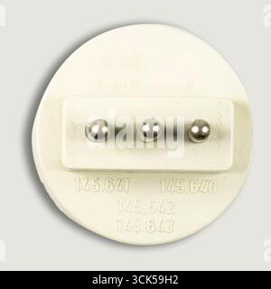 A white electrical plug with three metal pins, designed for connecting devices to a power source. Stock Photo