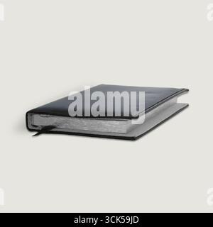 A closed black notebook with a textured cover, ideal for journaling or note-taking. Stock Photo