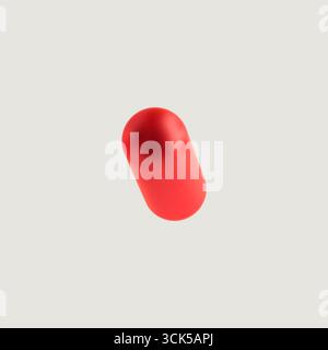 A single red capsule, commonly used as a medication or supplement, shown in a simple, isolated view. Stock Photo