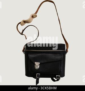 A small black leather bag with a shoulder strap, designed for carrying personal items or camera equipment. Stock Photo