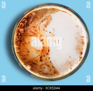 A close-up view of a coffee cup with swirling patterns of milk and coffee. Stock Photo