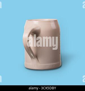 A simple ceramic mug with a handle, designed for holding beverages. Stock Photo