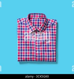 A folded checkered shirt featuring a mix of pink and blue colors, suitable for casual or semi-formal occasions. Stock Photo