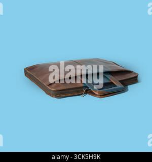 A sleek brown leather laptop bag with a handle, designed for carrying and protecting electronic devices. Stock Photo