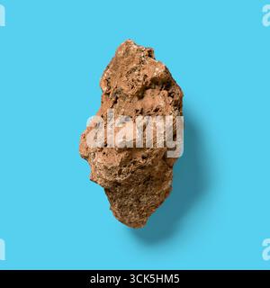 A rough, irregularly shaped rock with a textured surface, showcasing natural geological features. Stock Photo