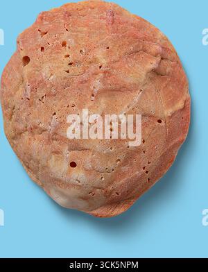 A close-up view of a textured, pinkish rock or mineral specimen with visible holes and variations in color. Stock Photo