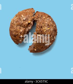 A broken round bread roll with visible grains and texture, highlighting its rustic appearance. Stock Photo