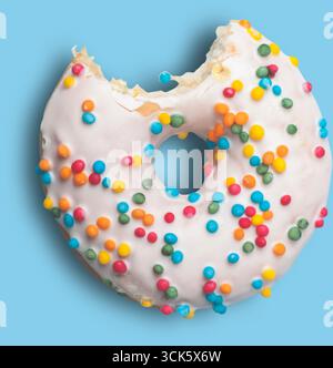 A partially eaten donut topped with colorful sprinkles, showcasing a sweet treat perfect for dessert or snack time. Stock Photo