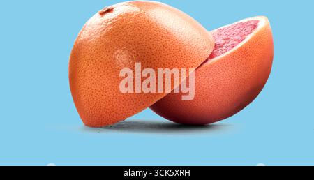 A halved grapefruit showcasing its vibrant pink flesh and textured rind, highlighting its juicy interior. Stock Photo