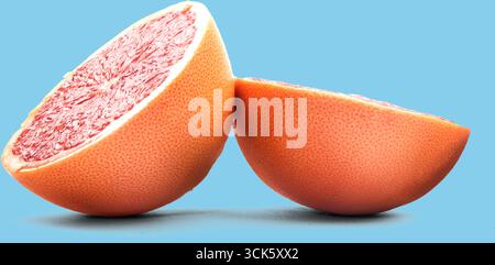 A vibrant pink grapefruit cut in half, showcasing its juicy interior and textured rind. Ideal for health-focused visuals or recipes. Stock Photo