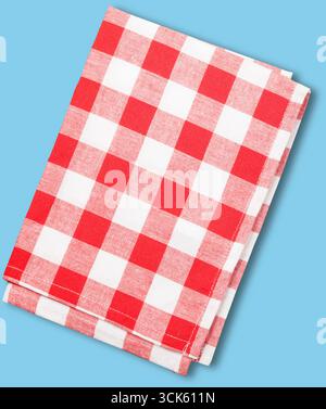 A folded red and white checkered tablecloth, commonly used for dining or picnic settings. Stock Photo