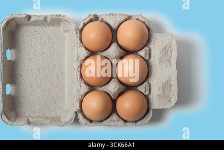 A carton containing six brown eggs, showcasing their smooth shells and natural color, ready for cooking or baking. Stock Photo