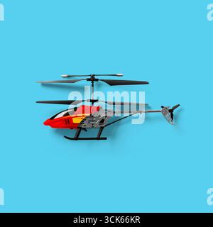 A red and black remote-controlled helicopter designed for leisure and entertainment. Stock Photo