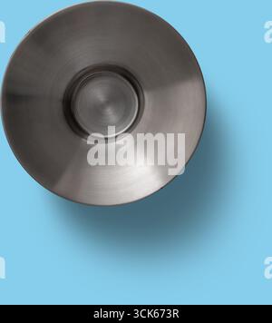 A top-down view of a metallic circular object, possibly a plate or a shallow bowl, showcasing a smooth, reflective surface. Stock Photo