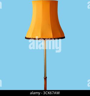A vintage-style floor lamp with a curved shade, providing warm lighting for home decor. Stock Photo