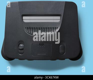 A classic gaming console designed for playing video games, featuring a cartridge slot and control buttons. Stock Photo