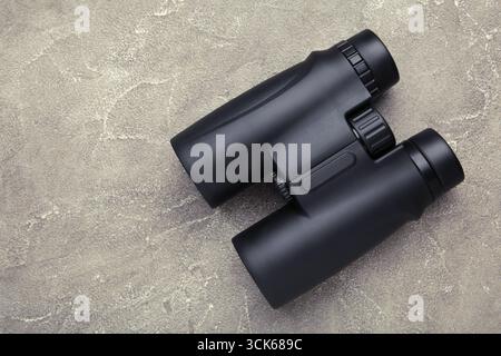 Binoculars on grey concrete background. Top view. Travel concept Stock Photo
