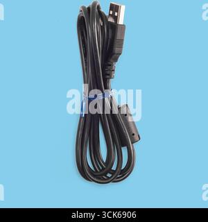 A coiled black USB cable used for data transfer and charging devices. Stock Photo