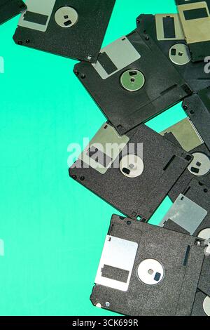 Overhead view of old black floppy disks placed on blue background in studio Stock Photo