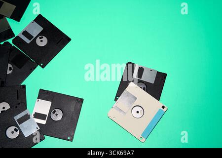 Overhead view of old black and white floppy disks placed on blue background in studio Stock Photo