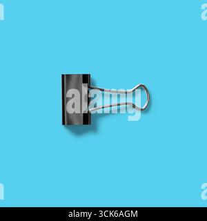 A black binder clip designed to hold papers together securely. Stock Photo