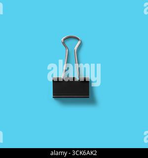 A black binder clip, commonly used for holding papers together, showcasing its simple yet effective design. Stock Photo