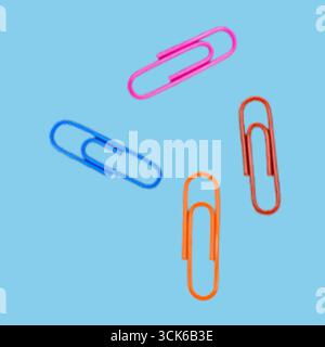 A collection of colorful paper clips arranged in a playful manner, showcasing their utility in organizing papers. Stock Photo