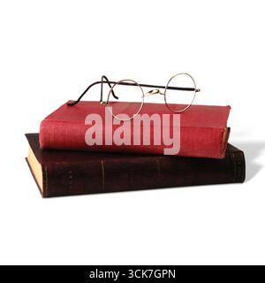 A pair of round glasses resting on two stacked books, symbolizing reading and knowledge. Stock Photo