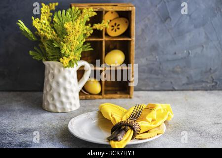 Festive table setting for holiday Easter dinner in bright yellow color Stock Photo