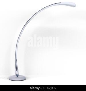 A sleek, modern floor lamp with a curved design, providing stylish lighting for any space. Stock Photo