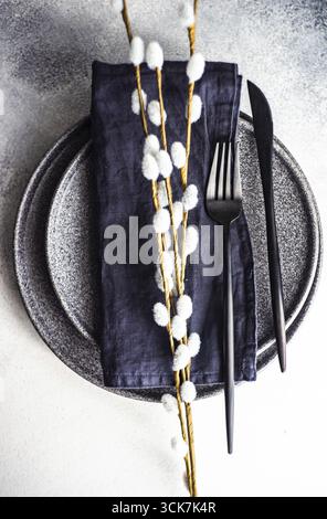 Place setting with stone plates and holiday decor served on concrete table with copy space Stock Photo