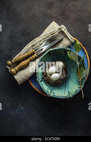 Easter festive table setting for holiday dinner on dark concrete background with copy space Stock Photo