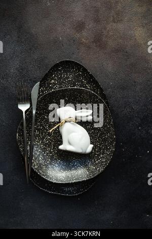 Easter festive table setting for holiday dinner on dark concrete background with copy space Stock Photo