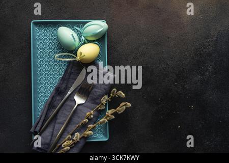 Easter festive table setting for holiday dinner on dark concrete background with copy space Stock Photo