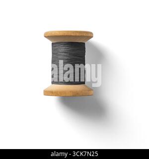 A wooden spool holding dark thread, commonly used in sewing and crafting projects. Stock Photo