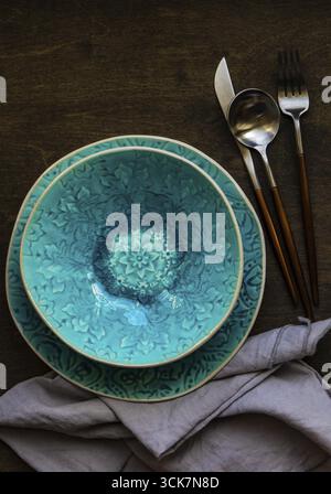 Rustic table setting with bright colored ceramic plates Stock Photo