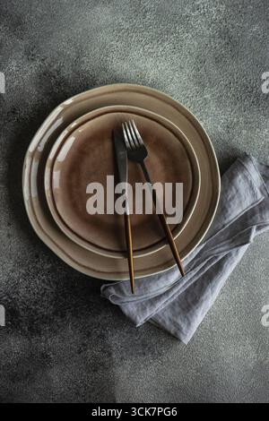 Cutlery set with empty plates on stone background with copy space Stock Photo