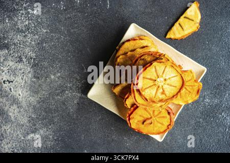 Traditional georgian dessert with dried persimmon fruits on dark concrete background Stock Photo