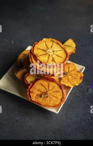Traditional georgian dessert with dried persimmon fruits on dark concrete background Stock Photo