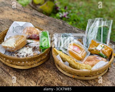 Tabanan, Bali, Indonesia - September 7, 2025: Traditional Indonesian snacks and cakes served in bamboo baskets Stock Photo