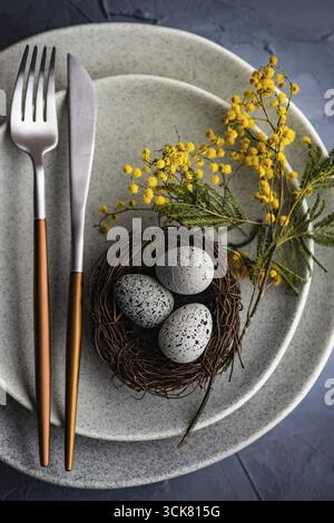 Festive table setting with mimosa flowers for easter holiday dinner Stock Photo