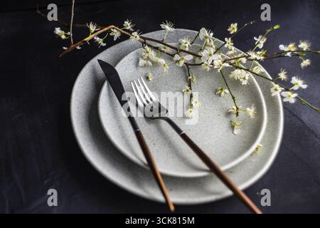 Spring table setting with peach blooming tree branch on wooden background with copy space Stock Photo