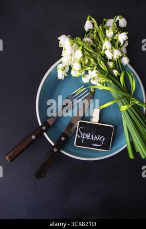 Feastive table setting for holiday Easter dinner decorated with spring snowdrop flowers on rustic table with copy space Stock Photo