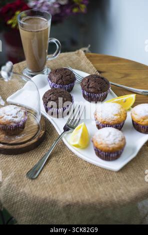 Tasty lemon and chocolate cupcakes in rustic interior Stock Photo