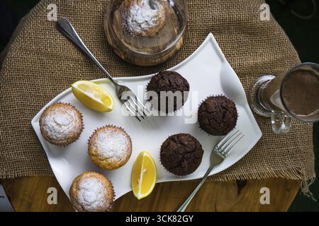 Tasty lemon and chocolate cupcakes in rustic interior Stock Photo