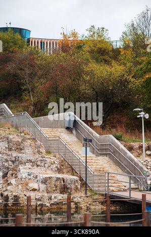 Outdoor staircase leading up a rocky hill with autumn foliage. Stock Photo